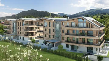 Modernes Mehrfamilienhaus in alpiner Architektur mit Holzfassade, Balkonen und Bergblick.