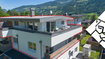 Moderne Architektur mit mehreren Balkonen und Terrassen, eingebettet in eine grüne Berglandschaft.
