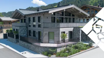 Modernes Chalet mit Holzfassade und Steinelementen, umgeben von alpiner Landschaft.