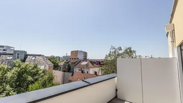 Geräumige Dachterrasse mit weitem Blick über die Stadt und umliegende Gebäude.