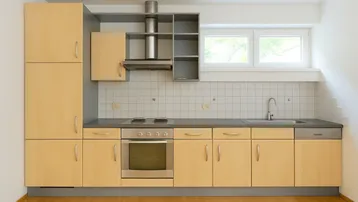Helle Einbauküche mit Holzfronten, Elektroherd, Spülmaschine und einem Fenster für Tageslicht.
