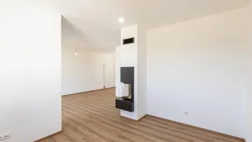 Heller Wohnbereich mit modernem Kaminofen und hochwertigem Laminatboden.