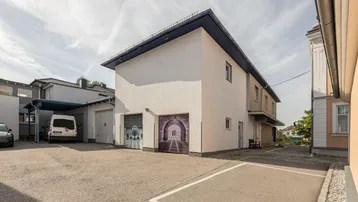 Gebäudeansicht mit Parkplätzen und Garagen, die eine kreative Gestaltung aufweisen.