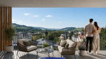 Geräumiger Balkon mit modernen Gartenmöbeln und weitem Blick über die Stadt und grüne Hügel.