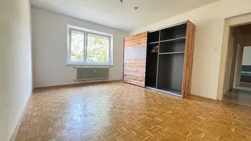 Geräumiges Schlafzimmer mit Parkettboden und einem großen Einbauschrank, hell und einladend.