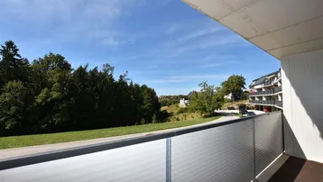 Balkon mit weitem Blick ins Grüne und auf die umliegende Wohnbebauung.