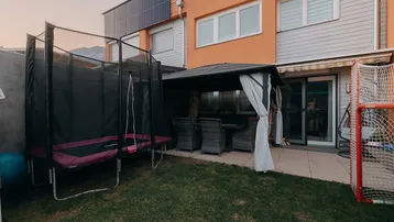 Gartenbereich mit Trampolin, Grillplatz und Spieltor, ideal für Familienaktivitäten.