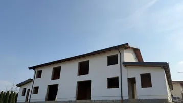 Neubau eines Einfamilienhauses mit weißer Fassade und Satteldach in der Bauphase.
