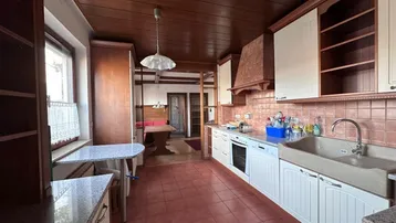 Geräumige Küche mit Essbereich, Holzdecke und traditionellen Einbauschränken.