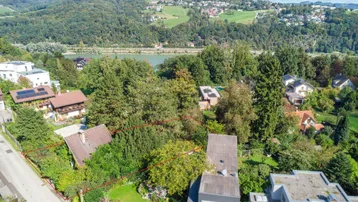 Weitläufige Luftaufnahme des Anwesens mit See- und Bergblick in der Ferne.