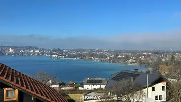Weitläufiger Seeblick mit Häusern, die teilweise mit Photovoltaikanlagen ausgestattet sind.