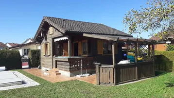 Charmantes Holzhaus im Chalet-Stil mit Garten, kleinem Pool und überdachter Terrasse.