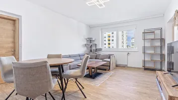 Helles Wohn- und Esszimmer mit modernem Design, Holzboden und Blick auf die Stadt.