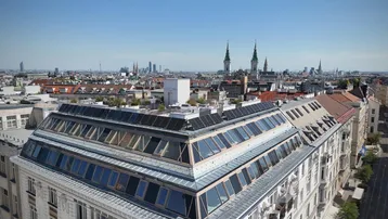 Panoramablick über die Stadt Wien mit historischen Gebäuden und moderner Dacharchitektur.