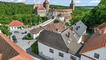 Malerische Luftaufnahme einer historischen Stadt mit imposanter Burg und grüner Umgebung.