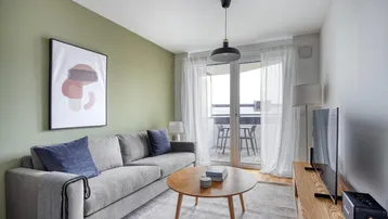 Helles Wohnzimmer mit modernem Sofa, Couchtisch und Zugang zum Balkon.