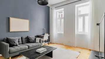 Helles Wohnzimmer mit modernem Design, Fischgrätparkett und einer stilvollen Akzentwand.