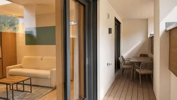 Geräumiger Balkon mit Sitzgelegenheiten und Blick auf die umliegende Landschaft.