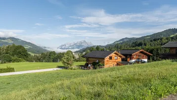 Charmante Holzchalets in einer idyllischen Berglandschaft mit weitem Blick auf die umliegenden Gipfel.