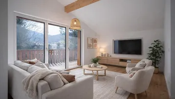 Helles Wohnzimmer mit Holzboden, hohen Decken und Zugang zu einem Balkon mit Bergblick.