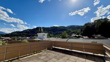 Sonnige Dachterrasse mit Bergblick und weitem Ausblick über die umliegende Landschaft.