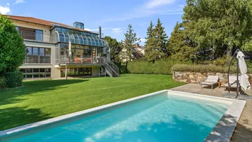 Großzügiger Gartenbereich mit privatem Swimmingpool und Blick auf die moderne Villa.