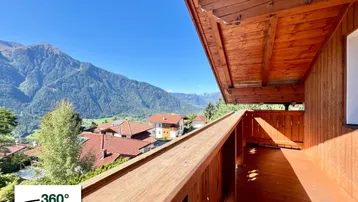 Geräumiger Holzbalkon mit atemberaubendem Bergblick und sonniger Ausrichtung.