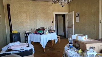 Wohnzimmer mit Kaminofen, Esstischen und Kronleuchter.