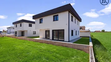 Moderne Doppelhaushälfte mit gepflegtem Rasen und Terrasse im Baugebiet.