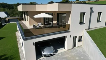 Moderne Architektur mit großer möblierter Terrasse, integrierter Garage und weitem Blick ins Grüne.