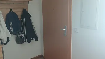 Eingangsbereich mit Garderobe, Holzboden und heller Wandgestaltung.