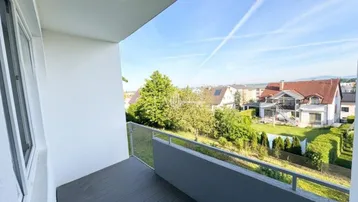 Balkon mit weitem Blick über die umliegende Wohngegend und grüne Gärten.