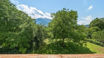 Panoramablick von einem Balkon auf üppige Bäume und die majestätische Bergkette.