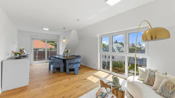 Helles, offenes Wohnzimmer mit Essbereich, Holzboden und Zugang zum Balkon.
