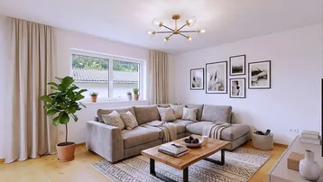 Helles Wohnzimmer mit gemütlichem Ecksofa, Holzboden und Blick ins Grüne.