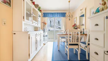 Heller Essbereich mit Holzboden, weißem Buffet und Zugang zum Balkon.