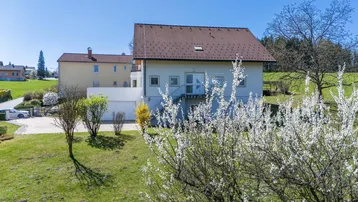 Freistehendes Einfamilienhaus mit Satteldach und gepflegtem Gartenbereich in ländlicher Umgebung.