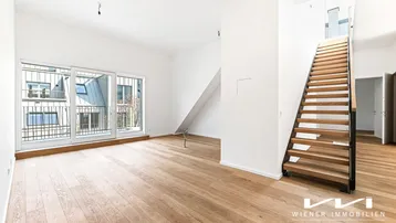 Heller Wohnbereich mit Eichenparkett, großen Schiebetüren und moderner Holztreppe.