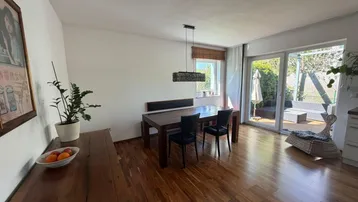 Heller Wohn- und Essbereich mit Laminatboden und direktem Zugang zur Terrasse.