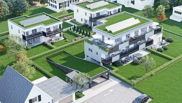 Luftaufnahme einer modernen Wohnanlage mit begrünten Dächern, Solarpaneelen und gepflegten Gärten.