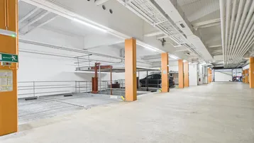 Geräumige Tiefgarage mit modernen Doppelparker-Systemen und heller Beleuchtung.