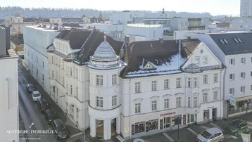 Luftaufnahme eines historischen Gebäudes mit markanter Architektur und umliegender Stadtlandschaft.