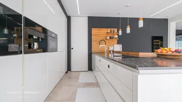 Detailansicht der modernen Küche mit hochwertigen Einbaugeräten und Holzdetails.