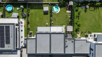Luftaufnahme von mehreren modernen Häusern mit Gärten und Pools in der Nachbarschaft.