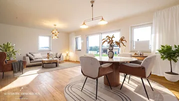 Helles, offenes Wohn-Esszimmer mit Holzboden, modernen Möbeln und Zugang zur Terrasse.