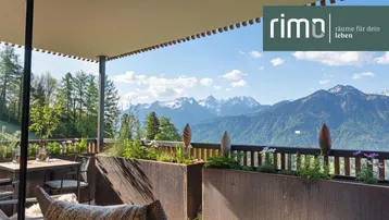 Geräumige Terrasse mit bequemen Sitzgelegenheiten, Sonnenschutz und atemberaubendem Bergblick.