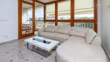 Helles Wohnzimmer mit beigem Ledersofa, modernem Couchtisch und Zugang zum Balkon.