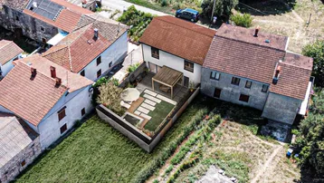 Luftaufnahme des Anwesens mit modern gestaltetem Gartenbereich, Terrasse und Pergola.