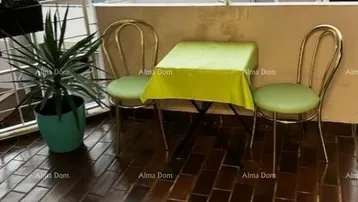 Kleiner Balkon mit Fliesenboden, einem Tisch und zwei Stühlen, ideal für eine Kaffeepause.