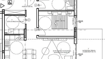 Grundriss einer Wohnung mit offenem Wohnbereich, zwei Schlafzimmern und überdachter Terrasse.
